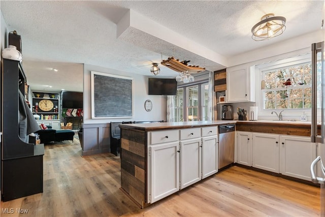 kitchen featuring white cabinetry, kitchen peninsula, light wood-type flooring, a textured ceiling, and stainless steel dishwasher