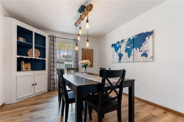 dining space featuring hardwood / wood-style floors and a textured ceiling