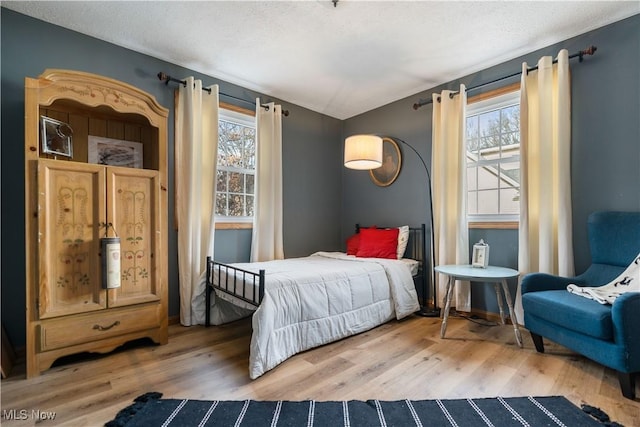 bedroom with a textured ceiling and hardwood / wood-style flooring