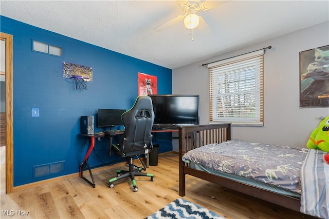 bedroom featuring ceiling fan, a textured ceiling, and hardwood / wood-style flooring