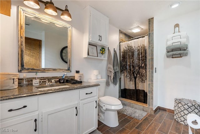 bathroom with curtained shower, toilet, and vanity