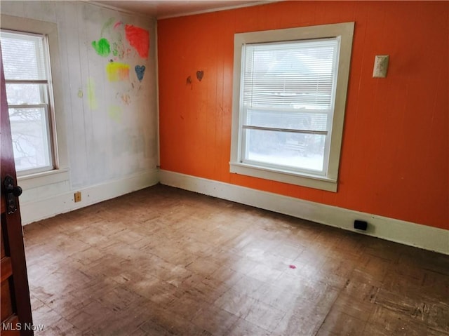 spare room with plenty of natural light and crown molding