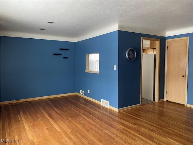 unfurnished room featuring a textured ceiling and hardwood / wood-style floors