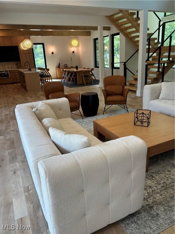 living room with sink, hardwood / wood-style floors, and beamed ceiling