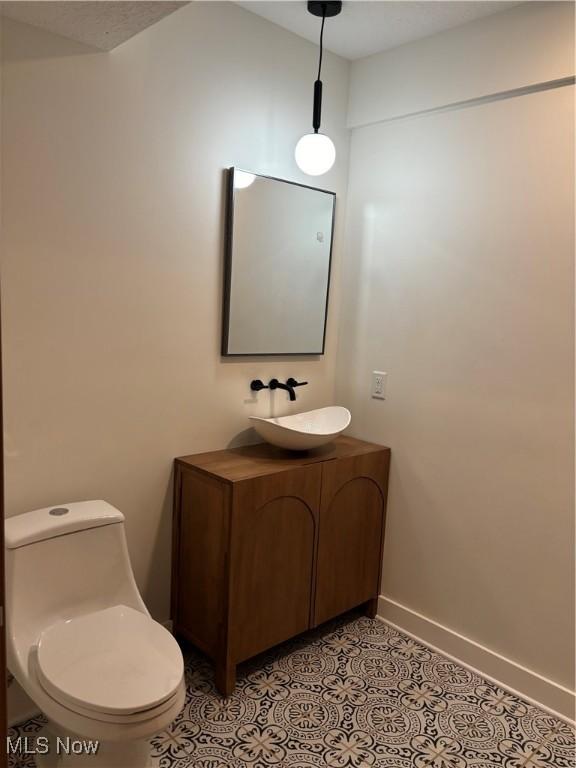 bathroom featuring toilet, tile patterned flooring, and vanity