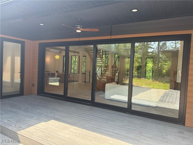 doorway to outside with ceiling fan and wood-type flooring