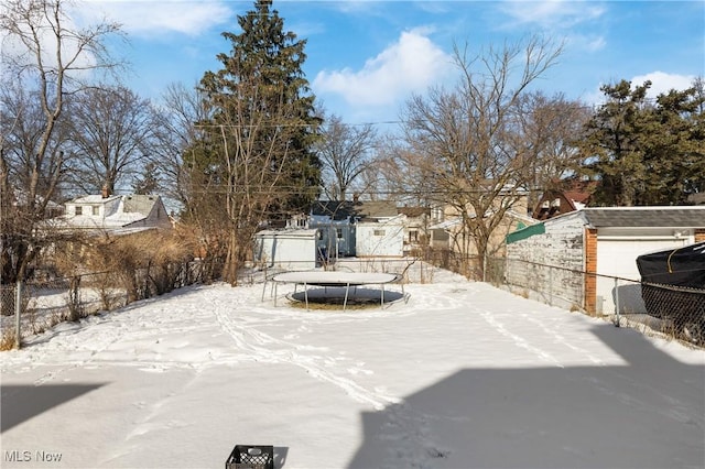 yard layered in snow featuring a trampoline