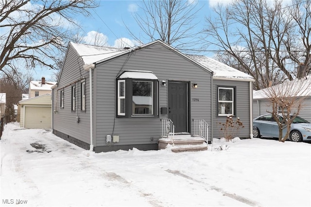 view of front of home with a garage and an outbuilding