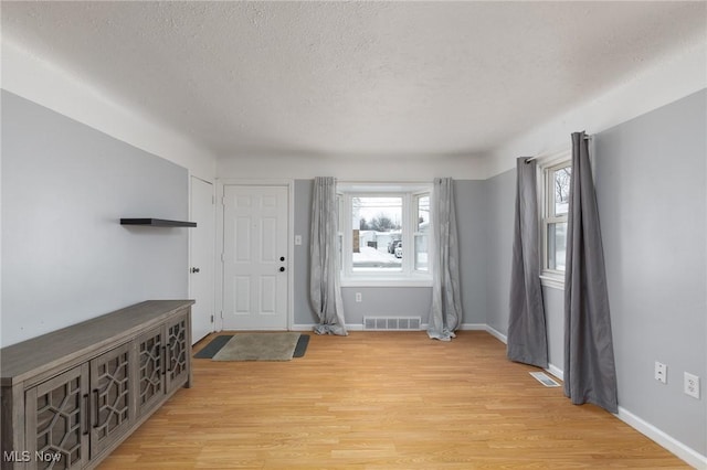 foyer with a textured ceiling and light hardwood / wood-style floors