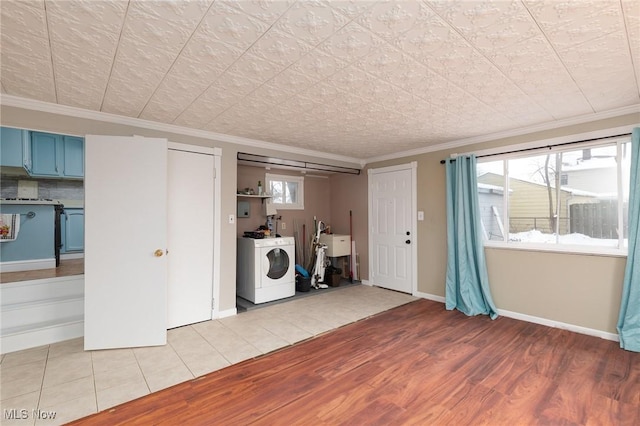 interior space with light wood-type flooring, crown molding, plenty of natural light, and washer / clothes dryer