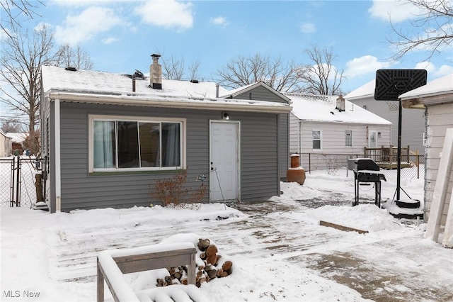 view of snow covered back of property