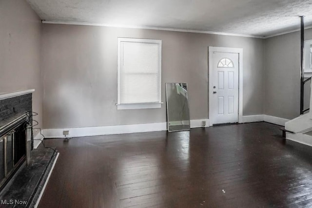 foyer with a textured ceiling, dark wood-type flooring, and ornamental molding