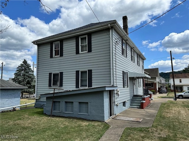 rear view of house featuring a lawn