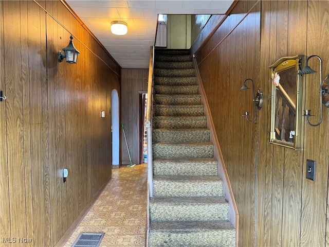 stairs featuring wooden walls