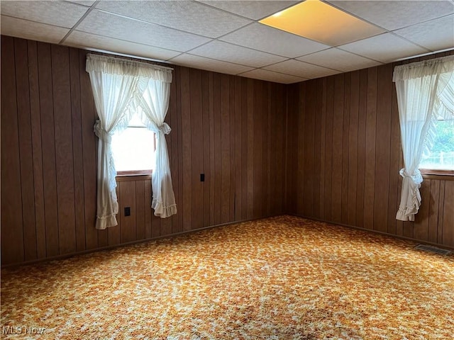 carpeted empty room with wooden walls