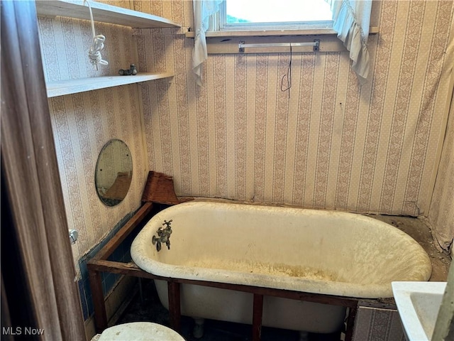 bathroom with a tub and wooden walls