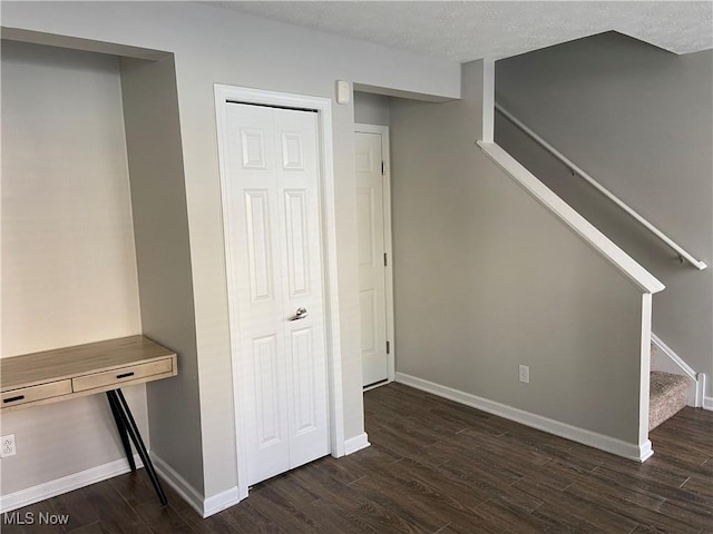 basement with a textured ceiling and dark hardwood / wood-style flooring