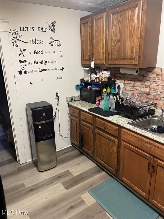 kitchen featuring tasteful backsplash, sink, and light hardwood / wood-style flooring