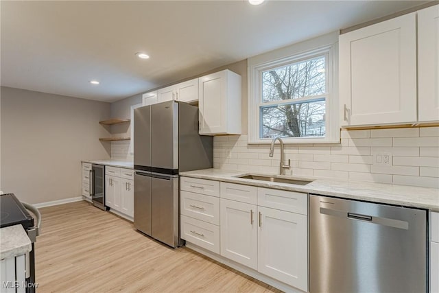 kitchen with wine cooler, decorative backsplash, sink, appliances with stainless steel finishes, and white cabinets