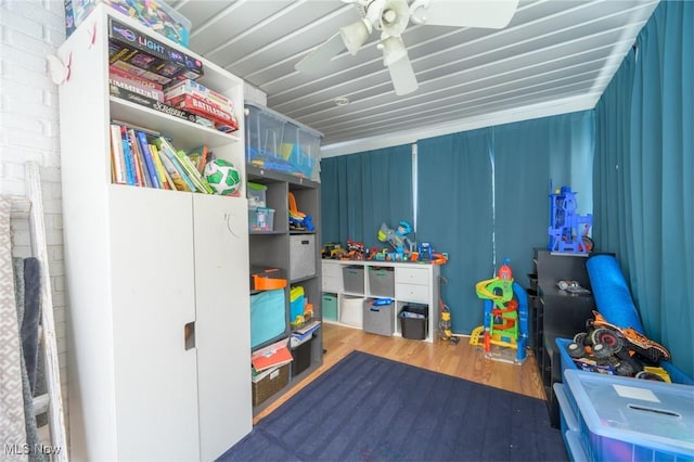 recreation room with dark wood-type flooring and ceiling fan