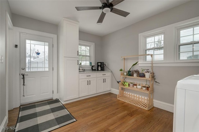 clothes washing area featuring light wood-type flooring, cabinets, washer / clothes dryer, and ceiling fan