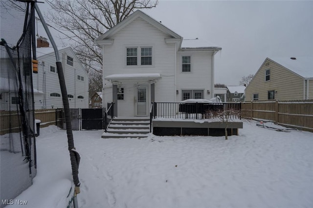 snow covered rear of property featuring a wooden deck