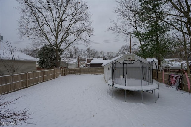 yard covered in snow featuring a trampoline