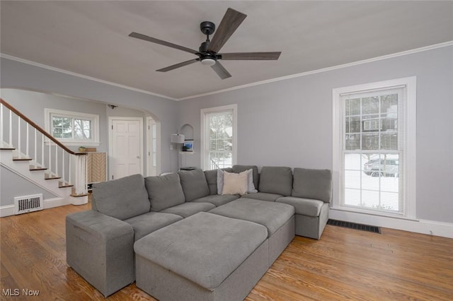 living room featuring ceiling fan, a healthy amount of sunlight, light hardwood / wood-style floors, and crown molding