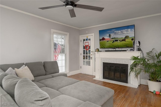 living room with ceiling fan, wood-type flooring, and ornamental molding