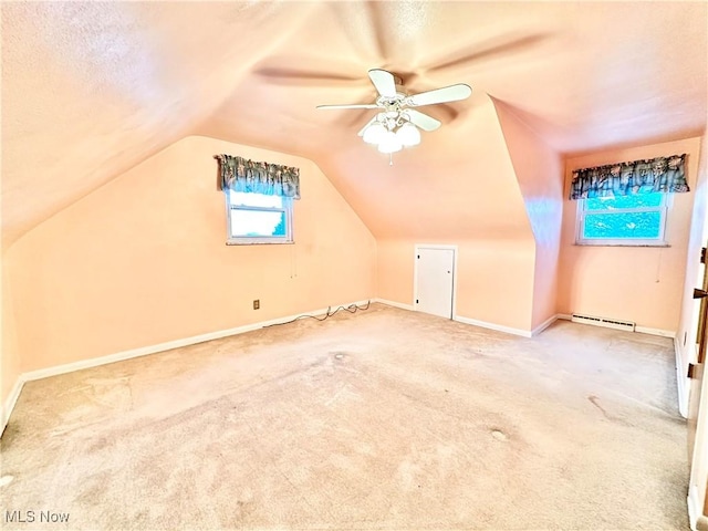 additional living space featuring ceiling fan, a baseboard heating unit, carpet floors, and lofted ceiling