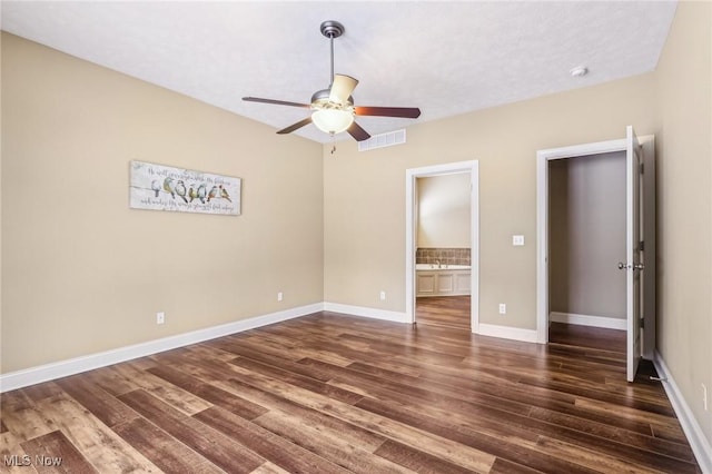 unfurnished bedroom with ceiling fan, dark hardwood / wood-style floors, and ensuite bathroom