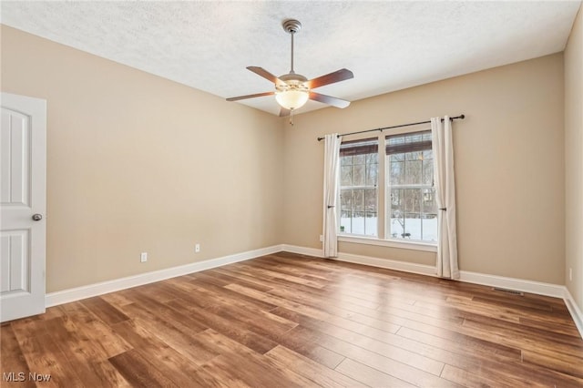 unfurnished room with ceiling fan, a textured ceiling, and hardwood / wood-style floors