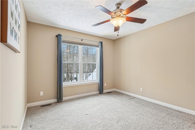 spare room featuring a textured ceiling, ceiling fan, and carpet