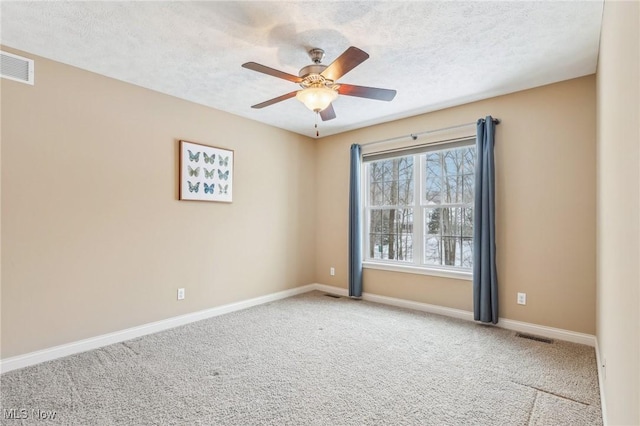 carpeted empty room with ceiling fan and a textured ceiling