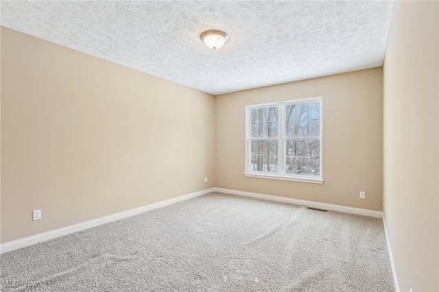 empty room with a textured ceiling and carpet flooring