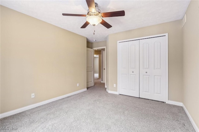 unfurnished bedroom featuring ceiling fan, light colored carpet, and a closet