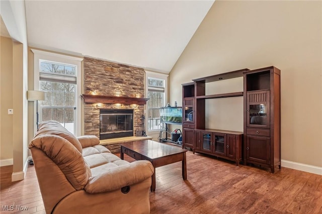 living room featuring a fireplace, hardwood / wood-style floors, and high vaulted ceiling