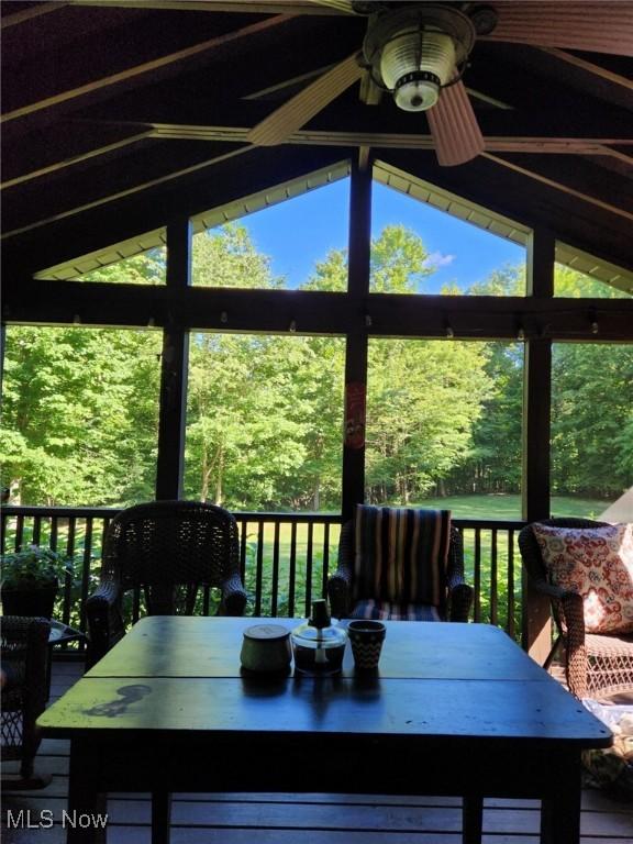 unfurnished sunroom with ceiling fan and vaulted ceiling