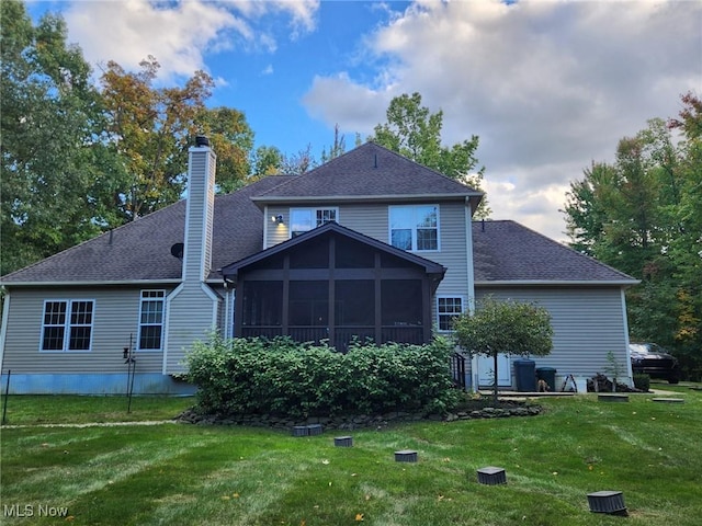 back of property with a sunroom and a yard