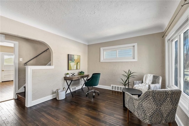 home office with dark hardwood / wood-style floors and a textured ceiling