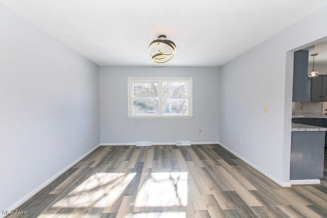 unfurnished dining area featuring dark hardwood / wood-style flooring