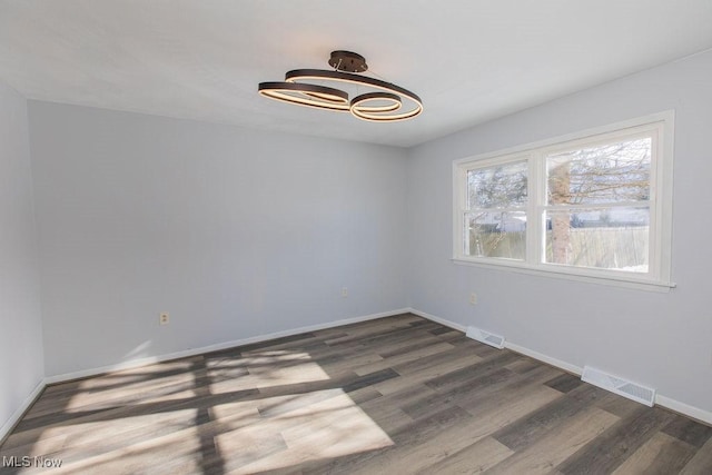 spare room featuring dark wood-type flooring