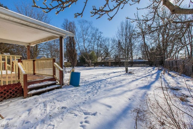 snowy yard with a deck