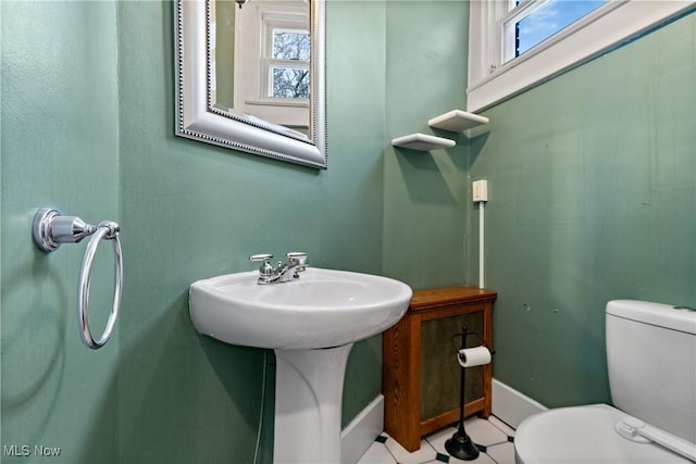 bathroom with a sink, baseboards, and toilet