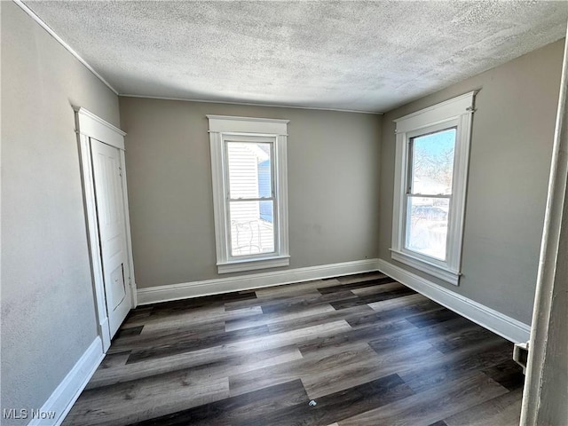 unfurnished room with a textured ceiling and dark hardwood / wood-style floors