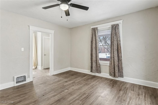 spare room featuring ceiling fan and dark wood-type flooring