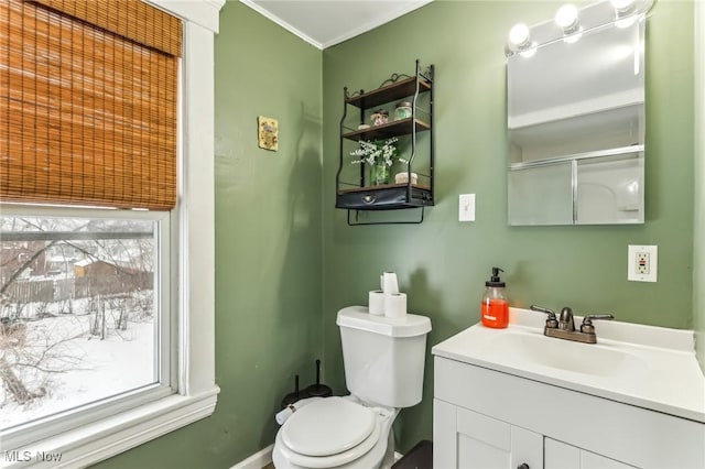 bathroom featuring toilet, vanity, and ornamental molding