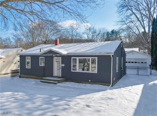 ranch-style house with a garage and an outbuilding