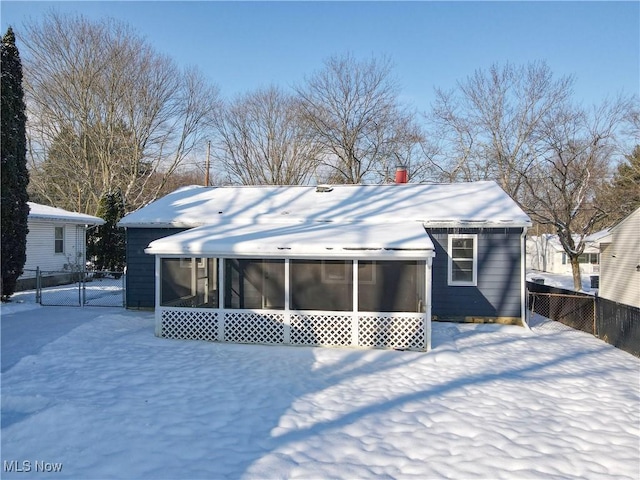 snow covered property with a sunroom