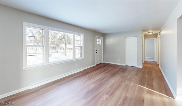 interior space featuring a baseboard heating unit and light hardwood / wood-style floors